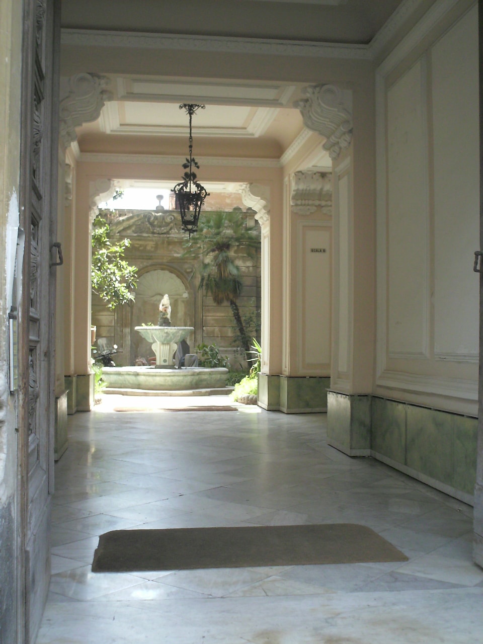 A luminous Neapolitan courtyard — archways, marble fountain, and the warmth of Italian sacred space